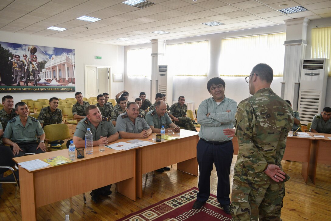 Staff Sgt. William Gordley, 149th Military Engagement Team, right, provided detailed information about the imagery and symbolism of the U.S. Flag during a military-to-military engagement June 15, 2017, at the Tashkent Institute of Information Technologies in Tashkent, Uzbekistan. A U.S. flag shoulder patch was presented to each Uzbek participant. (U.S. Army photo by Staff Sgt. Joshua Atanovich, 149th Military Engagement Team)