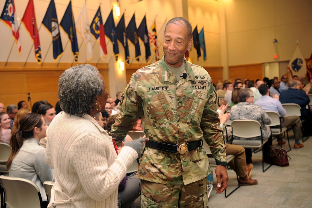 Army Brig. Gen. Charles Hamilton, DLA Troop Support commander, speaks with Jane Adams-Martin, a contract specialist with the Construction and Equipment supply chain, after presenting her with a commander’s coin during his final town hall June 20. Adams-Martin asked Hamilton his first question at his first town hall in July 2015.