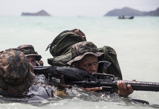MARINE CORPS TRAINING AREA BELLOWS - Lance Cpl. Armanie Singletary, a radio reconnaissance team operator with Radio Reconnaissance Platoon, 3rd Radio Battalion provides security during the Radio Reconnaissance Operator Course aboard Marine Corps Training Area Bellows, June 15, 2017. Singletary and his team members took turns providing security as the others removed their fins approaching the shore. (U.S. Marine Corps photo by Lance Cpl. Luke Kuennen)