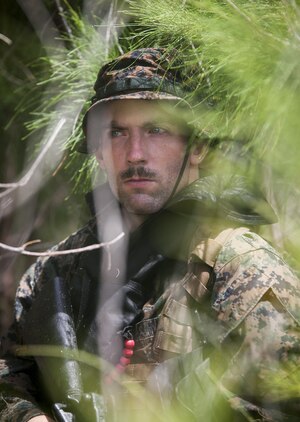 MARINE CORPS TRAINING AREA BELLOWS - Cpl. Ryan Ehlers, a radio reconnaissance team operator with Radio Reconnaissance Platoon, 3rd Radio Battalion posts security during an exercise aboard Marine Corps Training Area Bellows, June 15, 2017. After a two kilometer swim, Ehlers and his team took turns providing security while the others packed away their fins and changed into dry uniforms. (U.S. Marine Corps photo by Lance Cpl. Luke Kuennen)