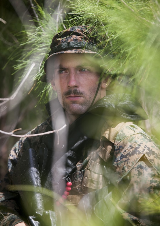 MARINE CORPS TRAINING AREA BELLOWS - Cpl. Ryan Ehlers, a radio reconnaissance team operator with Radio Reconnaissance Platoon, 3rd Radio Battalion posts security during an exercise aboard Marine Corps Training Area Bellows, June 15, 2017. After a two kilometer swim, Ehlers and his team took turns providing security while the others packed away their fins and changed into dry uniforms. (U.S. Marine Corps photo by Lance Cpl. Luke Kuennen)