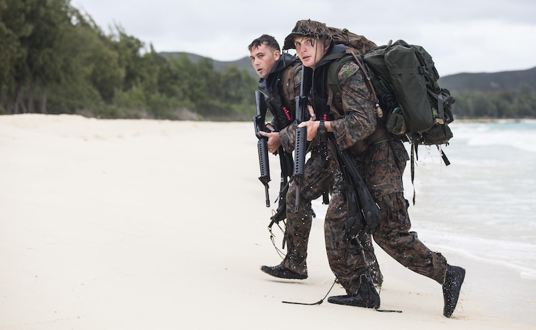 MARINE CORPS TRAINING AREA BELLOWS – (From front to back) Cpl. Kyle Smith alongside Cpl. Samuel Perry, both radio reconnaissance team operators with Radio Reconnaissance Platoon, 3rd Radio Battalion, walk onto a beach after swimming two kilometers in the Pacific Ocean during a Radio Reconnaissance Operator’s Course aboard Marine Corps Training Area Bellows, June 15, 2017. For 13 weeks, Marines conducted the Radio Reconnaissance Operator’s Course utilizing various training areas to push the students past their physical and mental limits to prepare themselves when they embed with a reconnaissance platoon. (U.S. Marine Corps photo by Cpl. Jesus Sepulveda Torres)