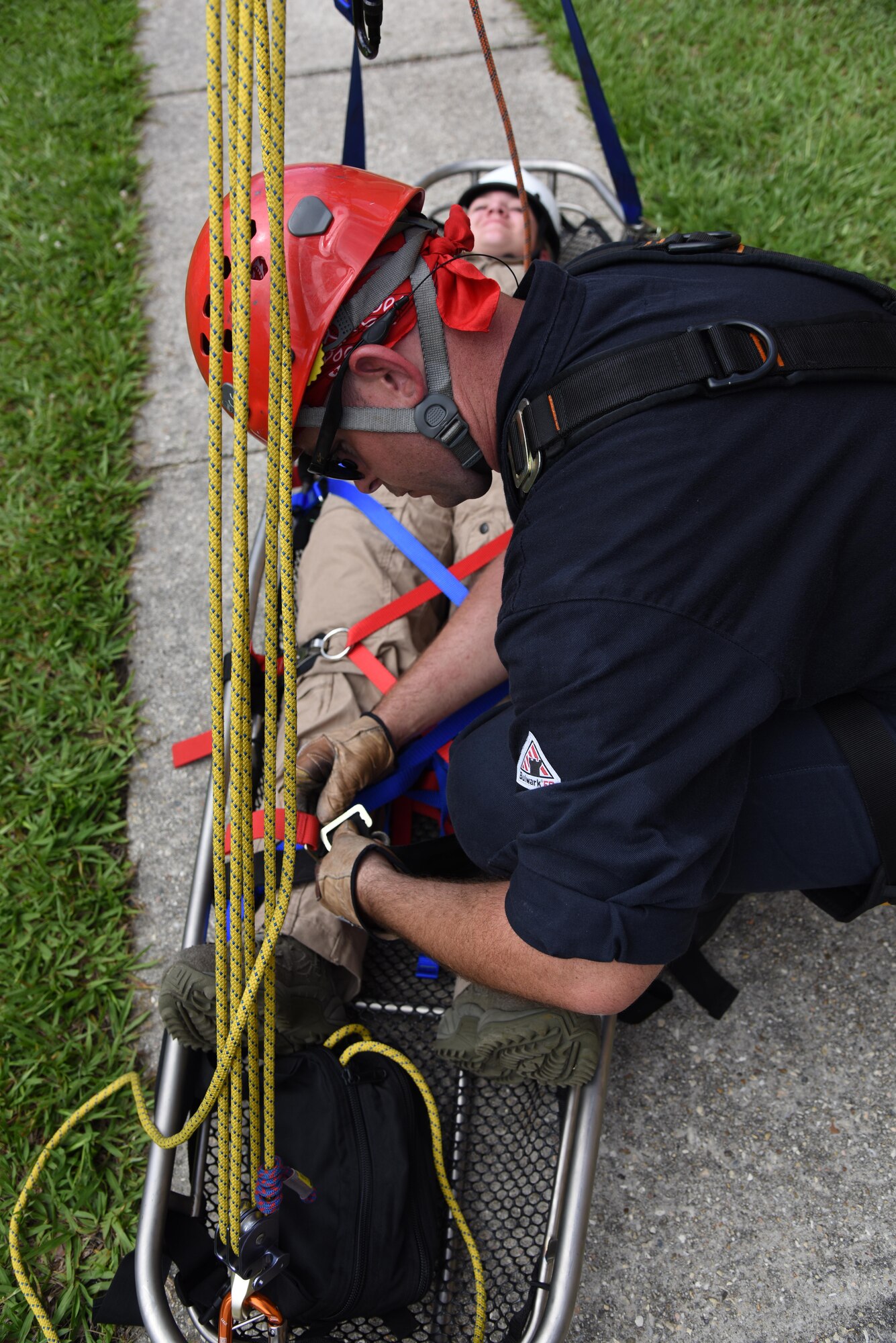 Robert Hornsby, Biloxi Firefighter, secures Airman 1st Class Hannah Reichert, Keesler Firefighter, in a stoke basket at the bottom of the Weather Training Complex during rope rescue operations training June 14, 2017, on Keesler Air Force Base, Miss. Keesler hosted the advanced rescue certification training course, which consisted of confined space rescue, high and low angle rescue and stokes basket rescue operations, for Keesler and Biloxi Firefighters. (U.S. Air Force photo by Kemberly Groue)