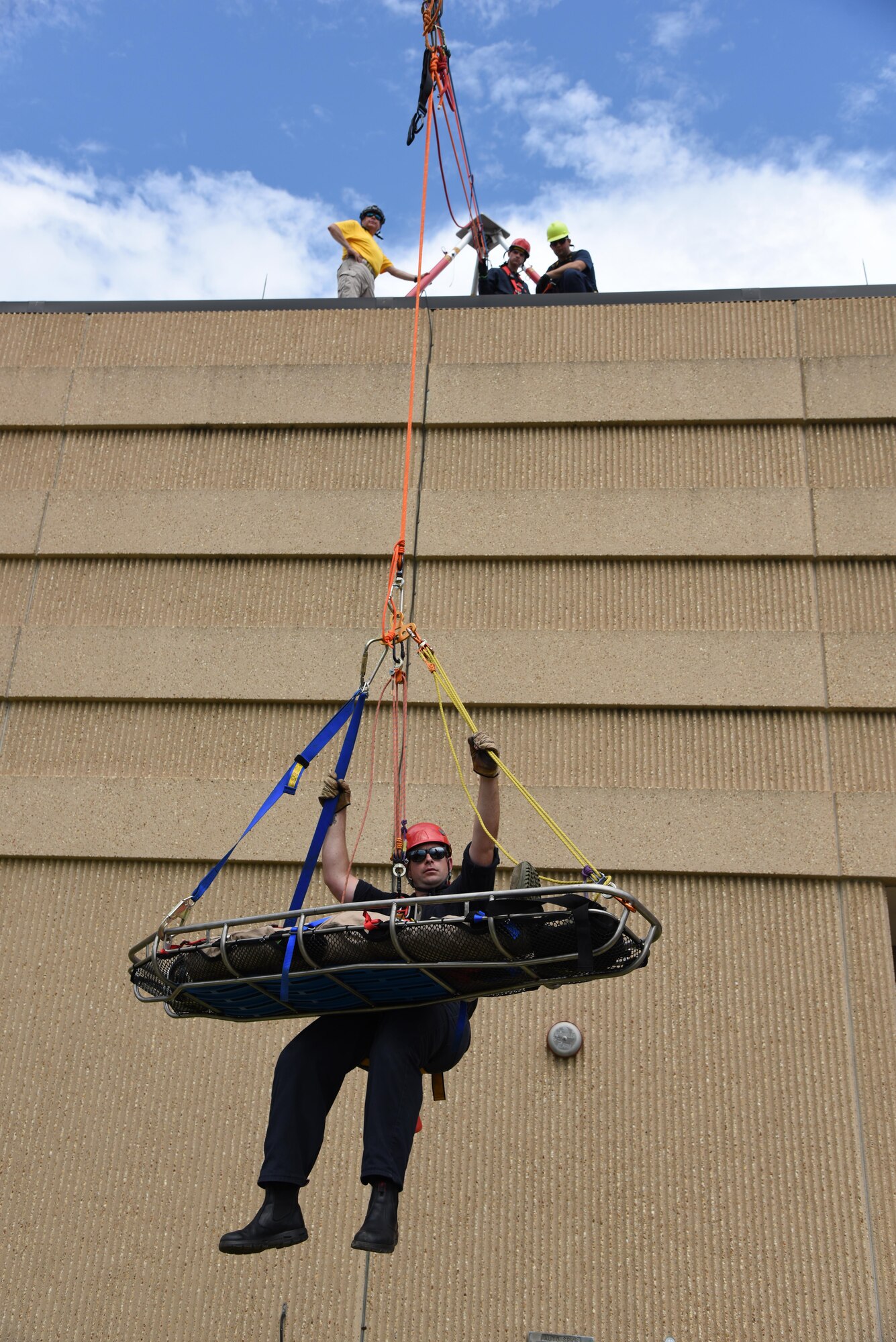 Robert Hornsby, Biloxi Firefighter, balances himself while being raised from the bottom of the Weather Training Complex with a “victim” during rope rescue operations training June 14, 2017, on Keesler Air Force Base, Miss. Keesler hosted the advanced rescue certification training course, which consisted of confined space rescue, high and low angle rescue and stokes basket rescue operations, for Keesler and Biloxi Firefighters. (U.S. Air Force photo by Kemberly Groue)