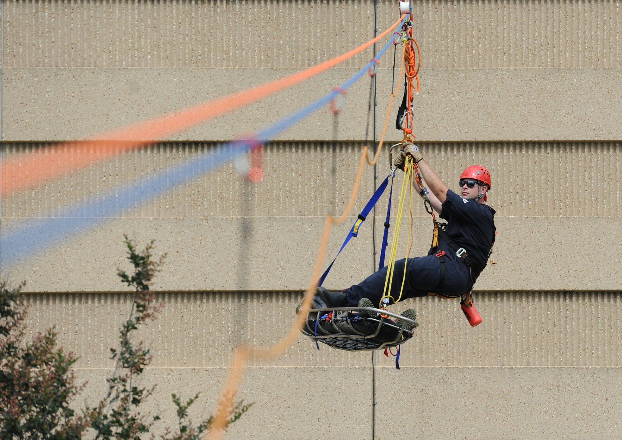 Robert Hornsby, Biloxi Firefighter, balances himself while being raised from the bottom of the Weather Training Complex with a “victim” during rope rescue operations training June 14, 2017, on Keesler Air Force Base, Miss. Keesler hosted the advanced rescue certification training course, which consisted of confined space rescue, high and low angle rescue and stokes basket rescue operations, for Keesler and Biloxi Firefighters. (U.S. Air Force photo by Kemberly Groue)