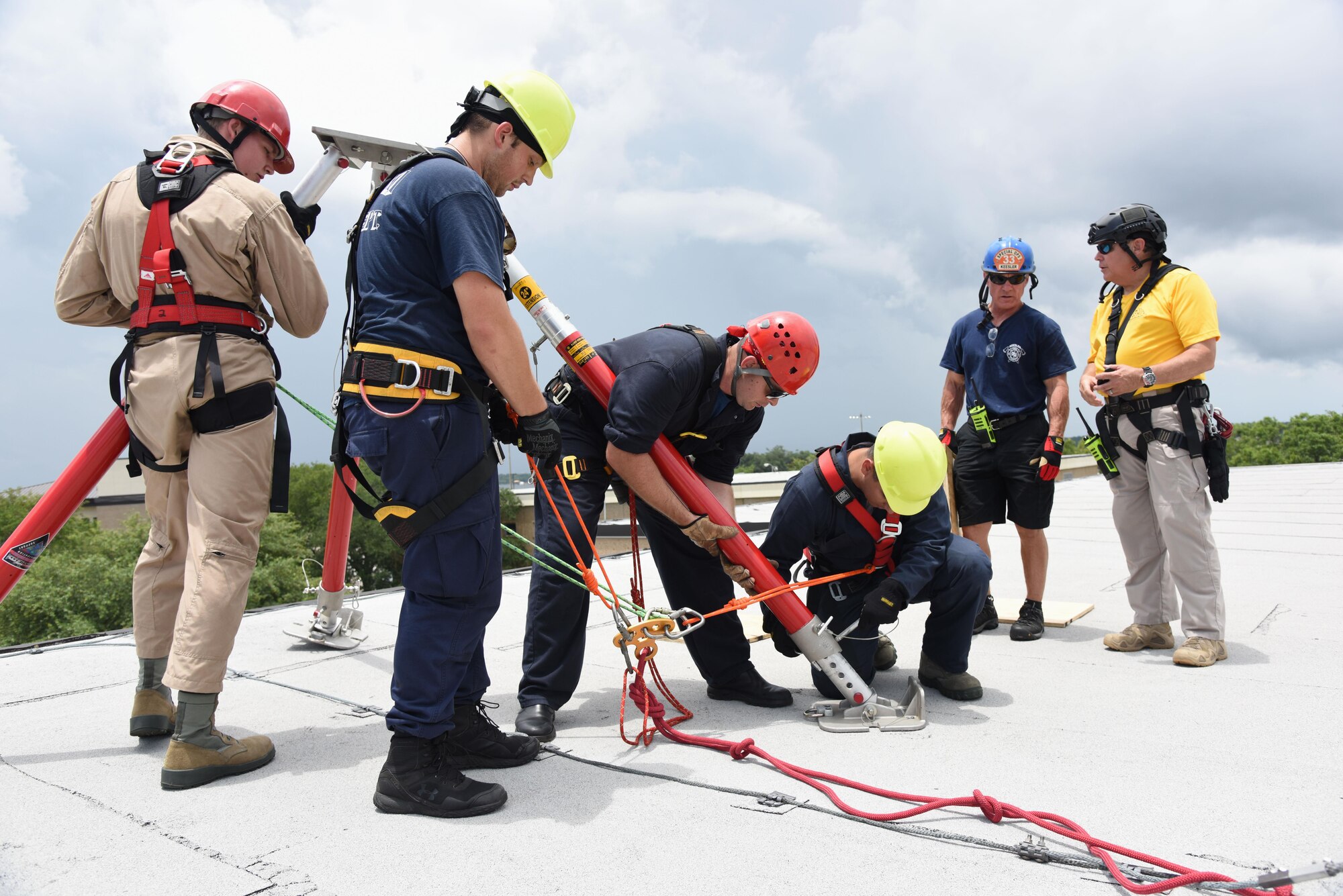 Members of the Keesler and Biloxi Fire Department, assemble a tripod atop of the Weather Training Complex during rope rescue operations training June 14, 2017, on Keesler Air Force Base, Miss. Keesler hosted the advanced rescue certification training course, which consisted of confined space rescue, high and low angle rescue and stokes basket rescue operations. (U.S. Air Force photo by Kemberly Groue)