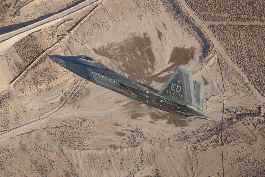 An F-22 Raptor assigned to the 411th Flight Test Squadron maneuvers over the Mojave Desert during a test mission. The 411th Flight Test Squadron’s quick integration of MGRS interface software enabled the Raptor to effectively engage ISIS targets in Syria. (Photo by Chad Bellay/Lockheed Martin)