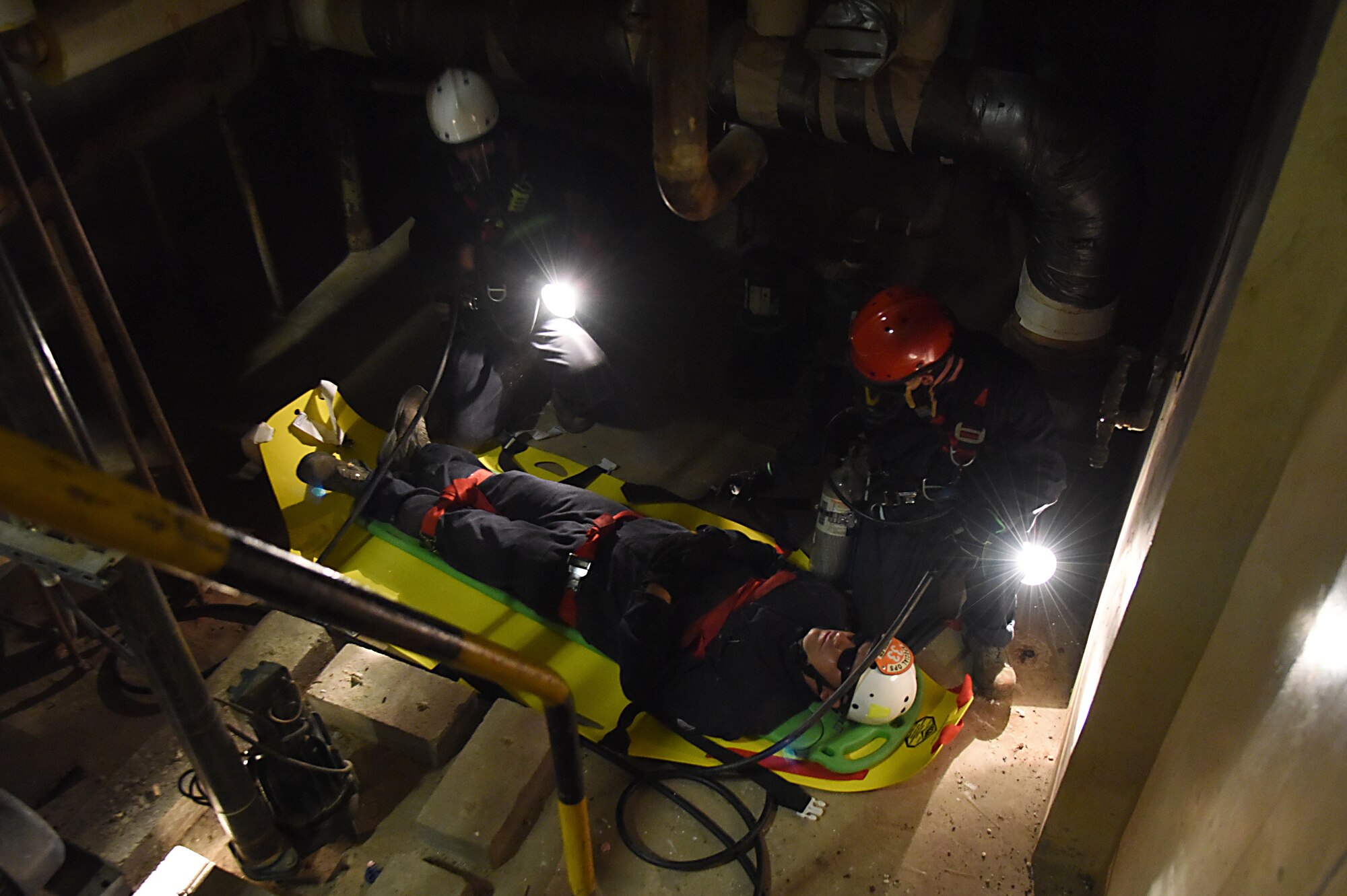 Members of the Keesler and Biloxi Fire Departments participate in confined space rescue operations training in the Keesler Medical Center June 16, 2017, on Keesler Air Force Base, Miss. Keesler hosted the advanced rescue certification training course, which consisted of confined space rescue, high and low angle rescue and stokes basket rescue operations. (U.S. Air Force photo by Kemberly Groue)