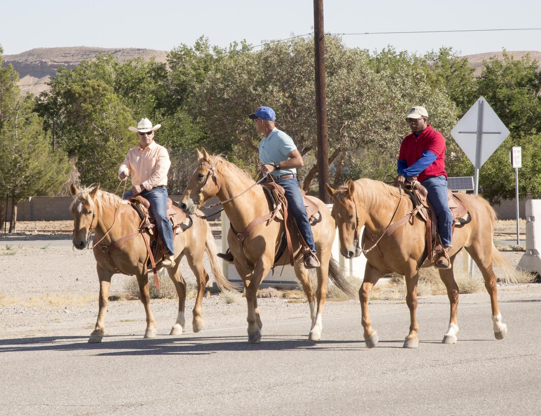 Col. Sekou S. Karega (right), commanding officer, MCLB Barstow,Terry Holladay, trainer, and base Sgt. Maj. Segio MartinesRuiz take an easy ride on Iwo Jima St. in preparration for the upcoming Cody Stampede and Rodeo scheduled for July 4 in Cody, Wyo.