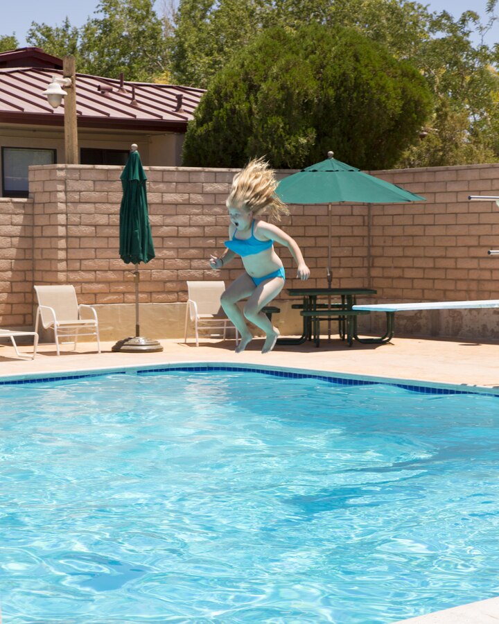Chloe Bledsoe takes a plunge off the diving board at the Oasis Pool and Water Park during the School Age Care Summer Camp held aboard Marine Corps Logistics Base Barstow, Calif., June 15. The program offers children of military and civilian employees on base an opportunity to enjoy activities throughout the summer.