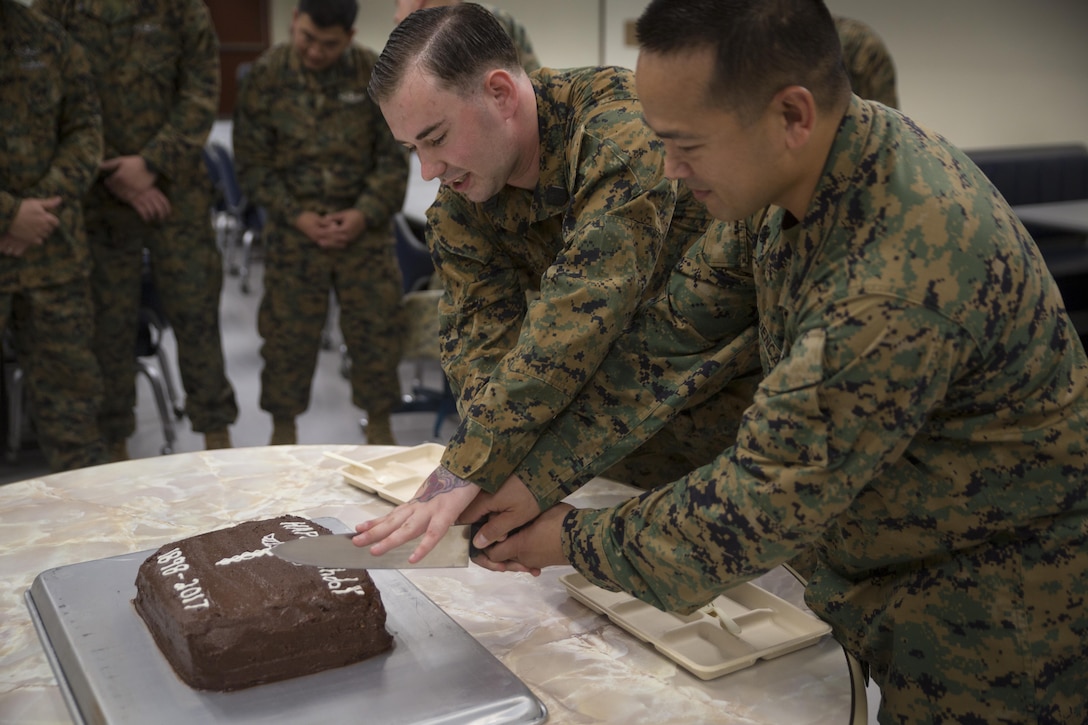 Chief Hospital Corpsman (Fleet Marine Force) Edgar E. Cuenca, right, a preventive medicine technician with Command Element, III Marine Expeditionary Force, and Hospital Corpsman (FMF) Joseph E. Clack, left, a corpsman assigned to 3rd Medical Battalion, 3rd Marine Logistics Group, III MEF, simultaneously cut a ceremonial cake during a celebration for the 119th birthday of the hospital corpsman rate at Camp Mujuk, Pohang, Republic of Korea, June 17, 2017. Marines from Bravo Company, 3rd Law Enforcement Battalion, III Marine Headquarters Group, III MEF and Corpsmen with 3rd Med Bn, 3rd MLG, III MEF came together to celebrate the birthday with a ceremonial cake cutting and birthday message reading from 3rd LE Bn senior enlisted advisor 1st Sgt. Derrick Benbow. (U.S. Marine Corps photo by Lance Cpl. Andy Martinez)
