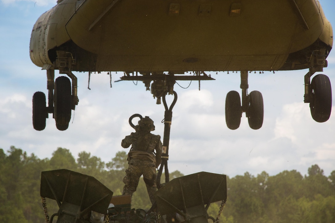 An Army artilleryman hooks up an M777 howitzer to a CH-47 Chinook during Exportable Combat Training Capability Rotation 17-04, a three-week training exercise at Fort Stewart, Ga., June 19, 2017. Army photo by Staff Sgt. Nikki Felton