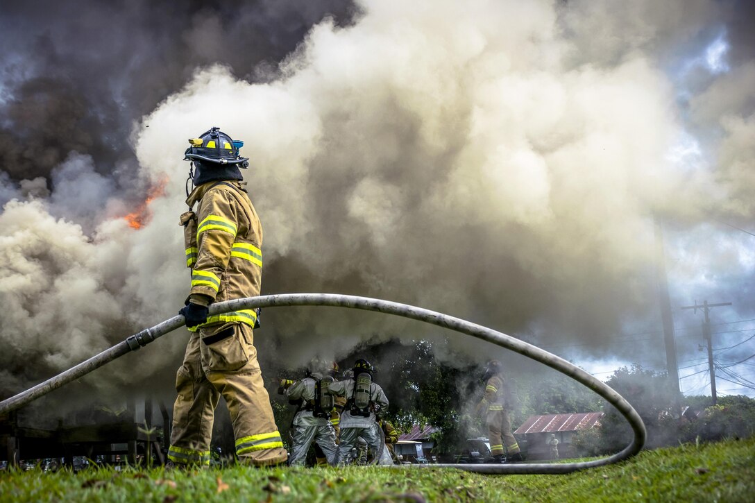 Air Force Senior Airman Christopher L. Allen assists his team during a firefighting training event at Soto Cano Air Base, Honduras, June 16, 2017. The 612th Air Base Squadron Fire Department hosted a public fire training event at the base. Air Force photo by Senior Airman Julie Kae