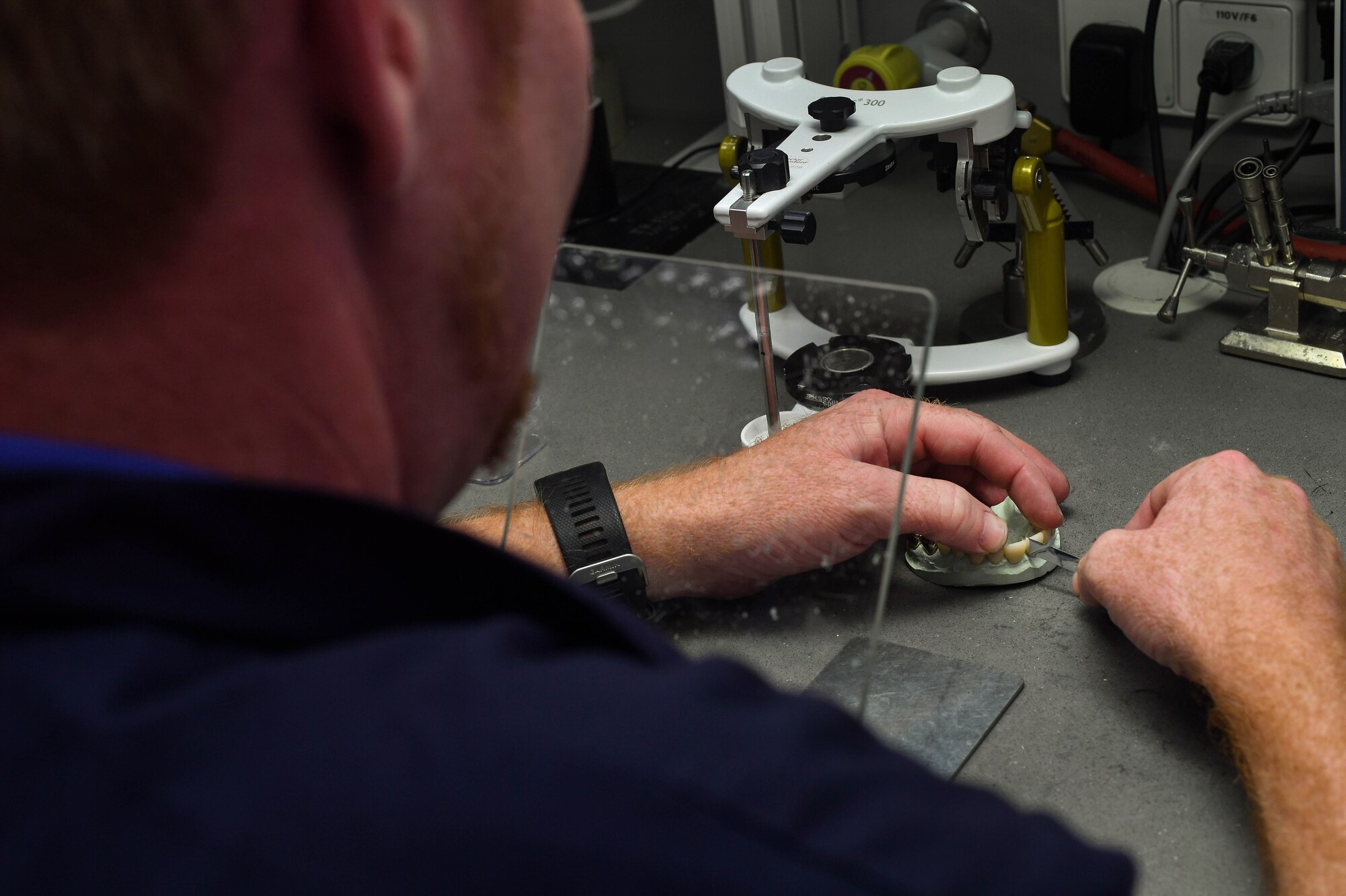 Chris York, 86th Dental Squadron dental lab technician, checks the contact between teeth on a set of caps to ensure they are properly fitted at the 86th DS Area Dental Lab on Ramstein Air Base, Germany, June 21, 2017. York made the caps for a U.S. Army Soldier, as the lab aids their sister service in a joint partnership that provides a faster turnaround time than sending Army cases back to the U.S. (U.S. Air Force photo by Senior Airman Tryphena Mayhugh)