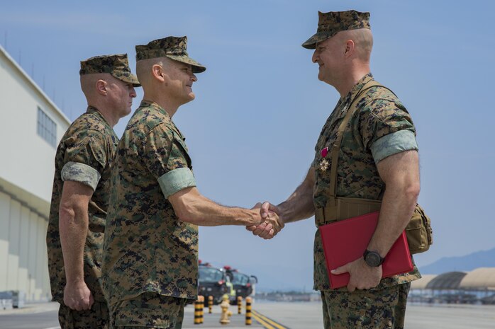 U.S. Marine Corps Maj. Gen. Russell A. Sanborn, left, the commanding general of 1st Marine Aircraft Wing, III Marine Expeditionary Force, shakes hands with U.S. Marine Corps Col. Daniel Shipley, right, former Marine Aircraft Group (MAG) 12 commanding officer, after an award presentation, during a change of command ceremony at Marine Corps Air Station Iwakuni, Japan, June 23, 2017. Shipley was awarded the Legion of Merit medal for his outstanding achievements and service to MAG-12. (U.S. Marine Corps photo by Lance Cpl. Joseph Abrego)