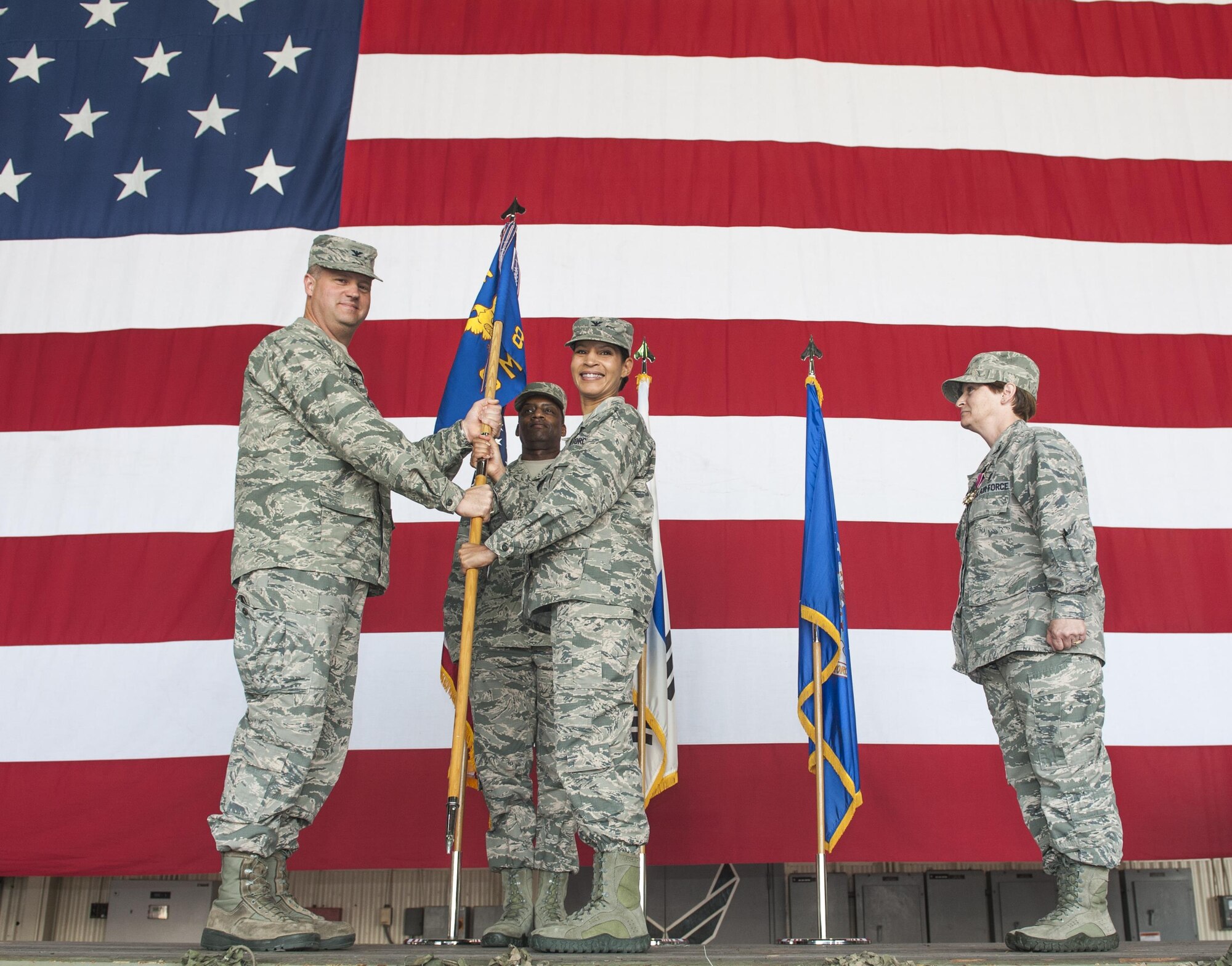 Col. Joann V. Palmer, 8th Medical Group commander, receives the guidon from Col. David Shoemaker, 8th Fighter Wing commander, during a change of command ceremony at Kunsan Air Base, Republic of Korea, June 23, 2017. Shoemaker presided over the ceremony in which Col. Lisa A. Davison relinquished command of the 8th MDG to Palmer. (U.S. Air Force photo by Senior Airman Colville McFee/Released)