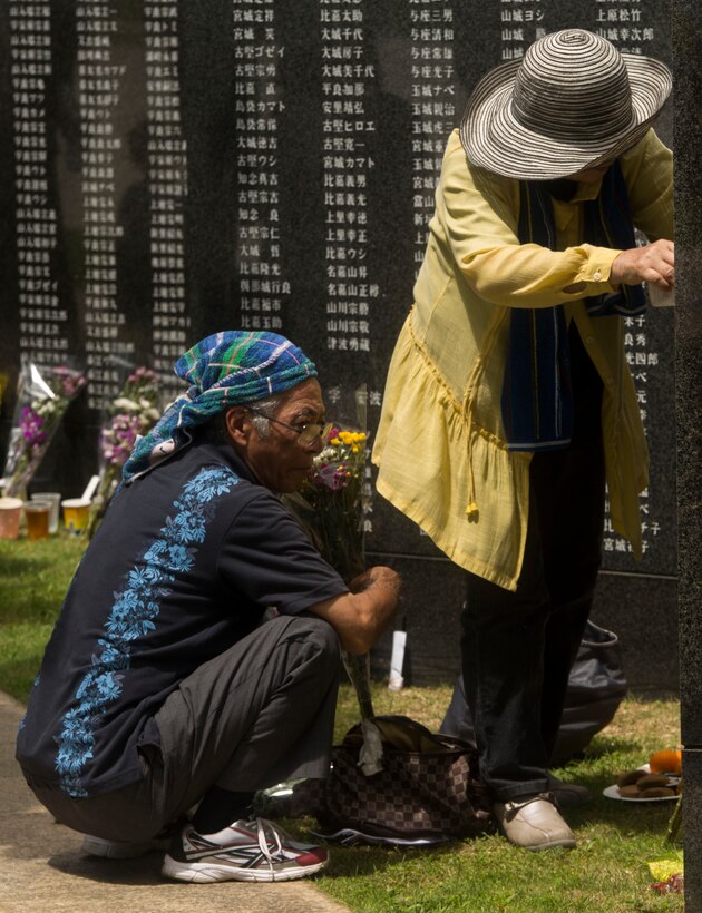 Okinawan residents place flowers and pray at the Cornerstone of Peace memorial wall during the 2017 Okinawa Memorial Day service June 23, 2017 at Peace Memorial Park, Itoman, Japan. The ceremony brought together service members and Okinawan residents to honor all who lost their lives in the Battle of Okinawa. The memorial walls are inscribed with over 240,000 names of people who died, regardless of nationality, civilian or military status in the battle. During the ceremony all who attended stood for a moment of silence honoring those who gave the ultimate sacrifice for their country. (U.S. Marine Corps photo by Lance Cpl. Charles Plouffe)