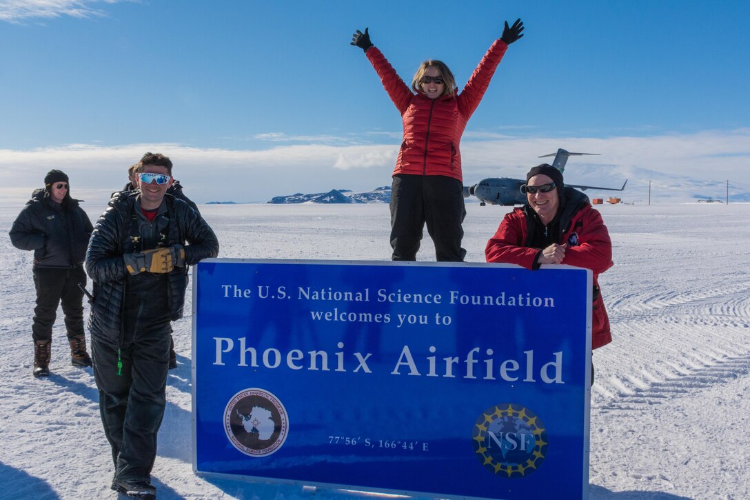 CRREL and National Science Foundation researchers celebrate the first landing of a C-17 on Phoenix Runway with C-17 in the background. (1st Place, Customers, 2017 CRREL Photo Contest)