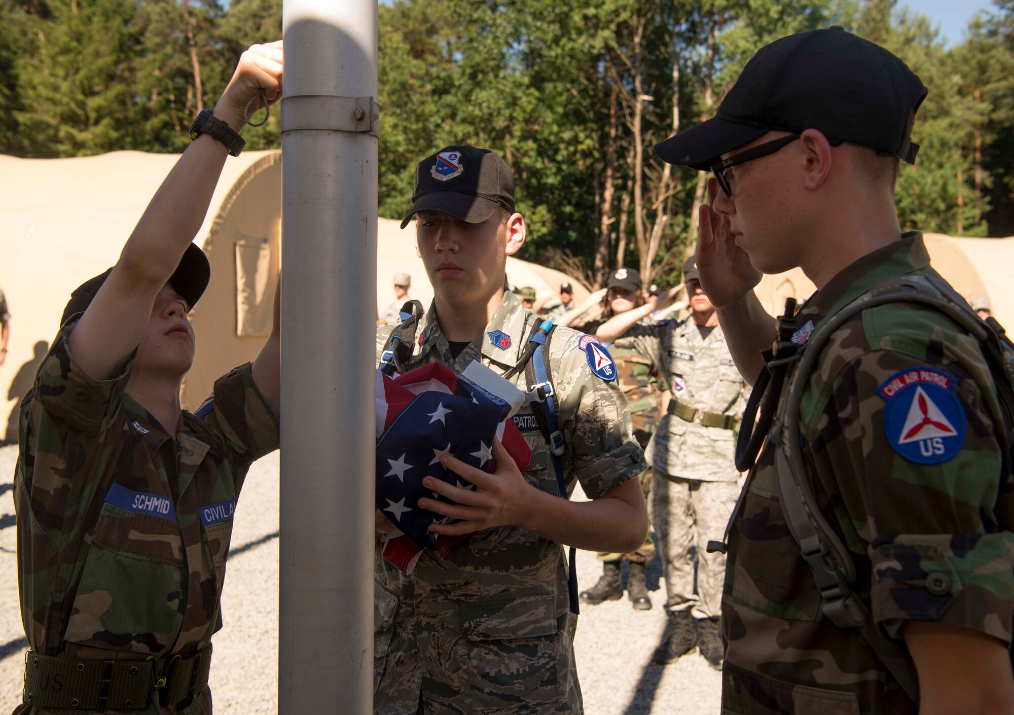 Cadets with the Civil Air Patrol European Encampment take down a flag during Retreat on Ramstein Air Base, Germany, June 19, 2017. The encampment curriculum encompasses four core areas: aerospace education, leadership development, character development, and physical fitness. The curriculum is designed, in part, to prepare cadets for a possible military aerospace career. (U.S. Air Force photo by Senior Airman Elizabeth Baker)