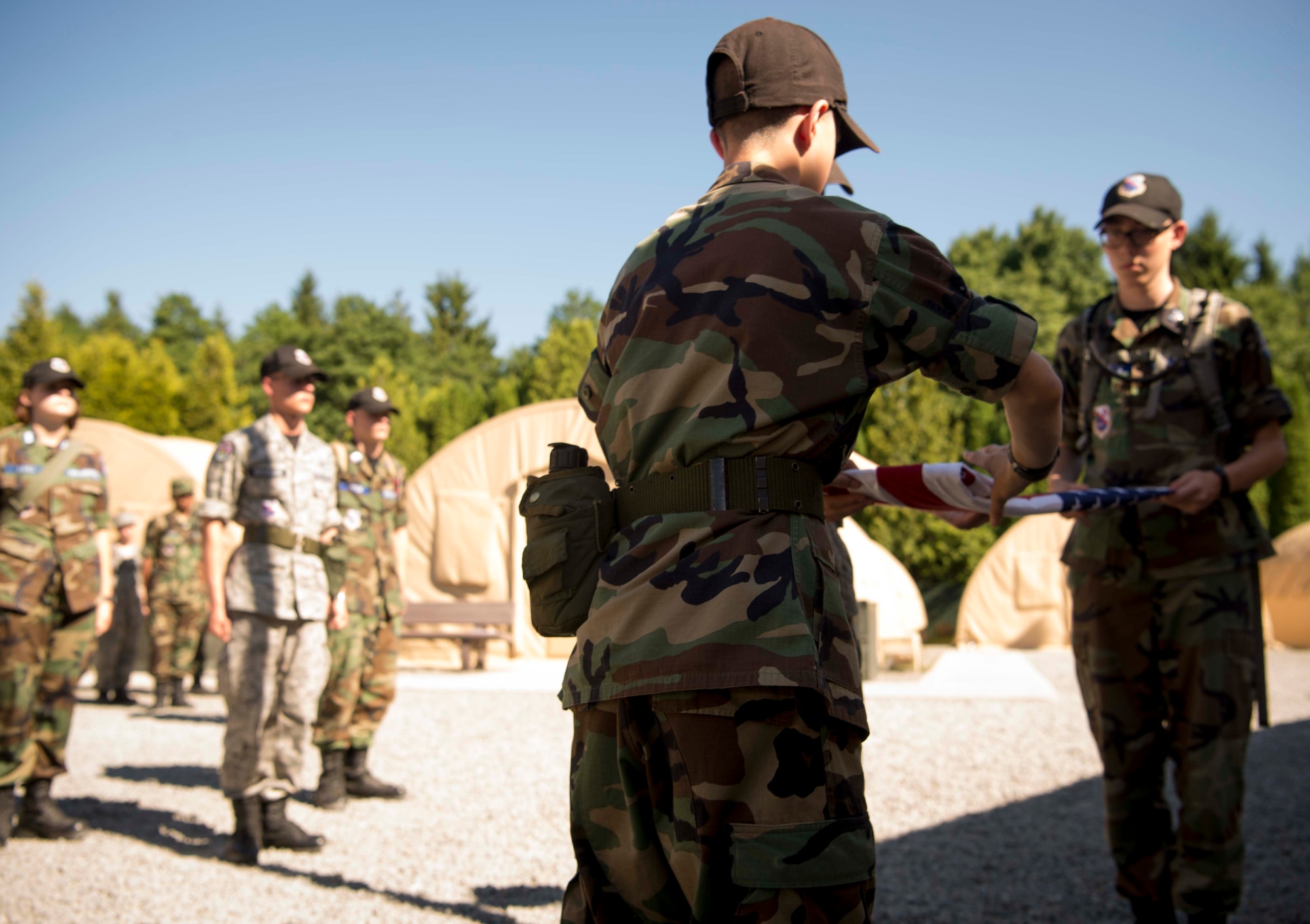 Civil Air Patrol European Encampment cadets fold a flag during retreat on Ramstein Air Base, Germany, June 19, 2017. The cadet encampment is a summer program for young men and women, ages 12-21, who are part of the CAP Cadet Program. It is designed to transform American youth into leaders and build knowledge of aerospace throughout the U.S. population. (U.S. Air Force photo by Senior Airman Elizabeth Baker)