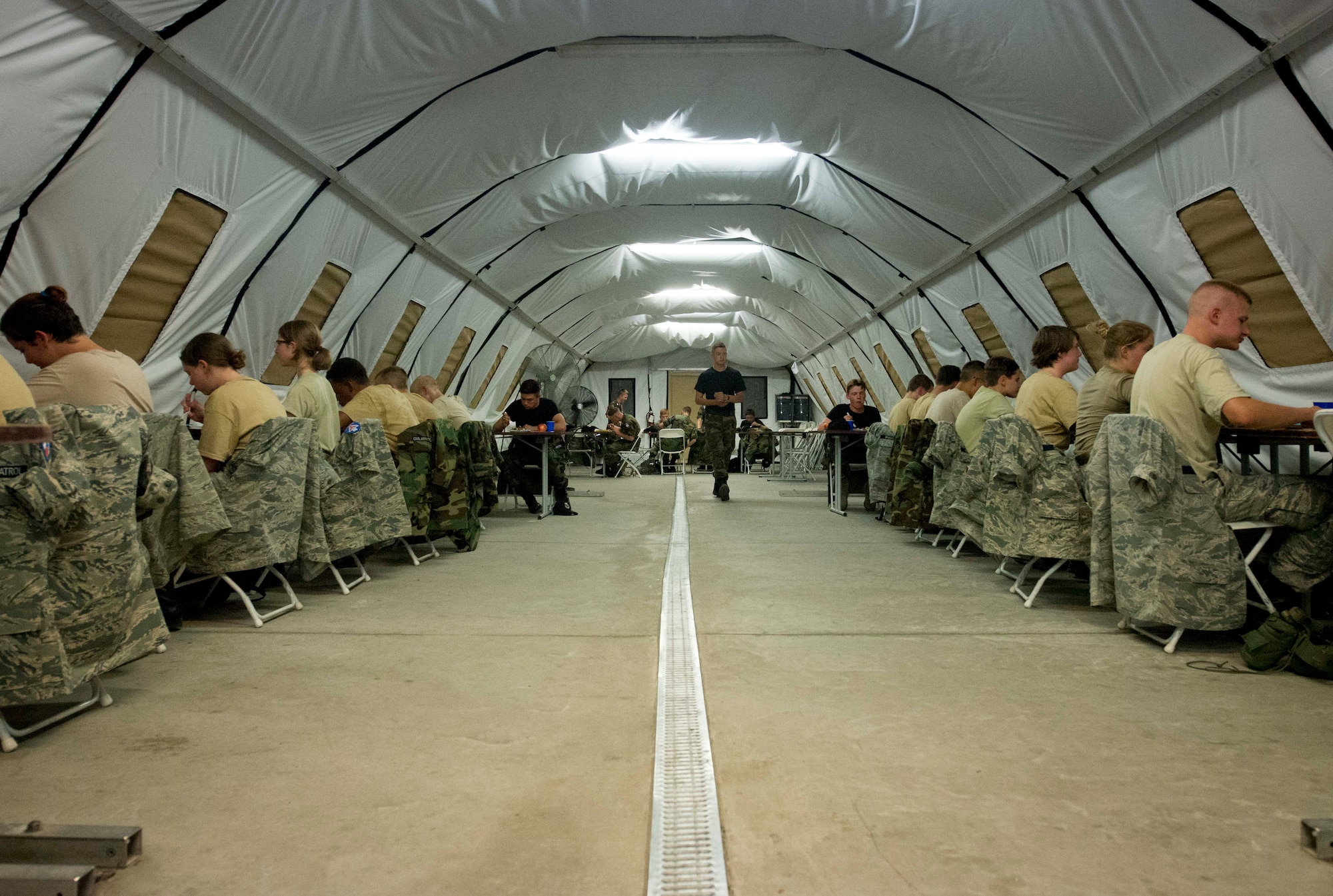 Cadets eat in a deployment tent during the Civil Air Patrol European Encampment on Ramstein Air Base, Germany, June 19, 2017. Instead of sleeping in and enjoying a lazy week of summer, cadets chose to better themselves by practicing leadership, increasing knowledge and building physical fitness in a military setting. (U.S. Air Force photo by Senior Airman Elizabeth Baker)