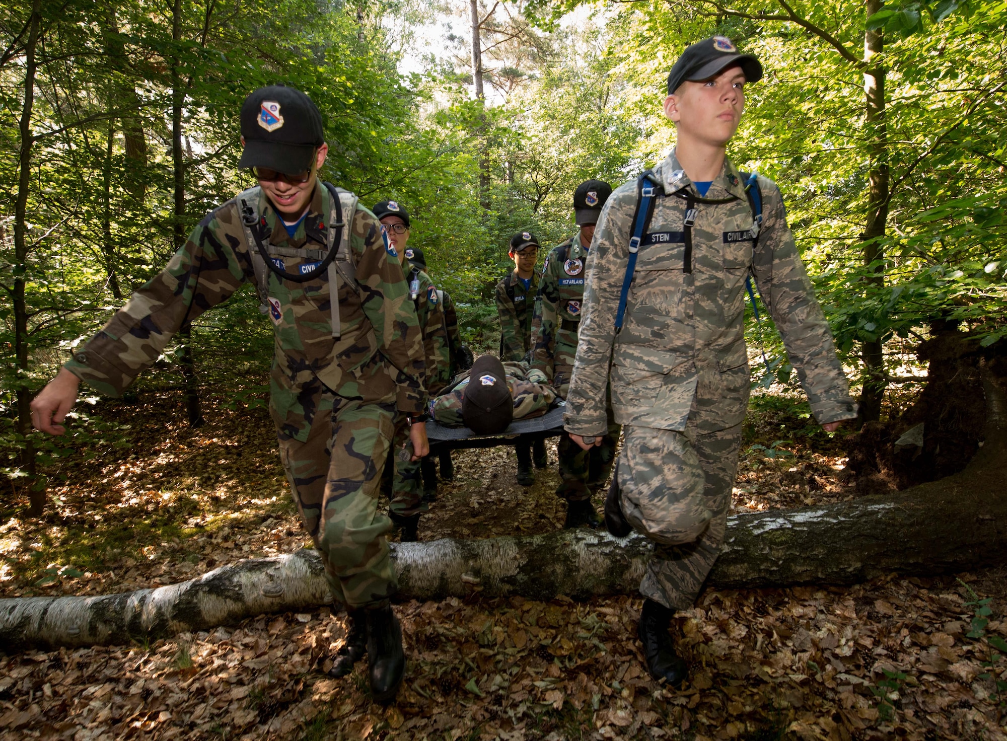 Civil Air Patrol European Encampment cadets carry a stretcher bearing a fellow cadet through a woodland obstacle course on Ramstein Air Base, Germany, June 21, 2017. During the encampment, the cadets had many challenges to overcome from learning proper dress, drill and ceremony, to figuring out how to communicate as they carried out challenges like the woodland obstacle course. These challenges are designed to transform American youth into leaders and build knowledge of aerospace throughout the U.S. population. (U.S. Air Force photo by Senior Airman Elizabeth Baker)