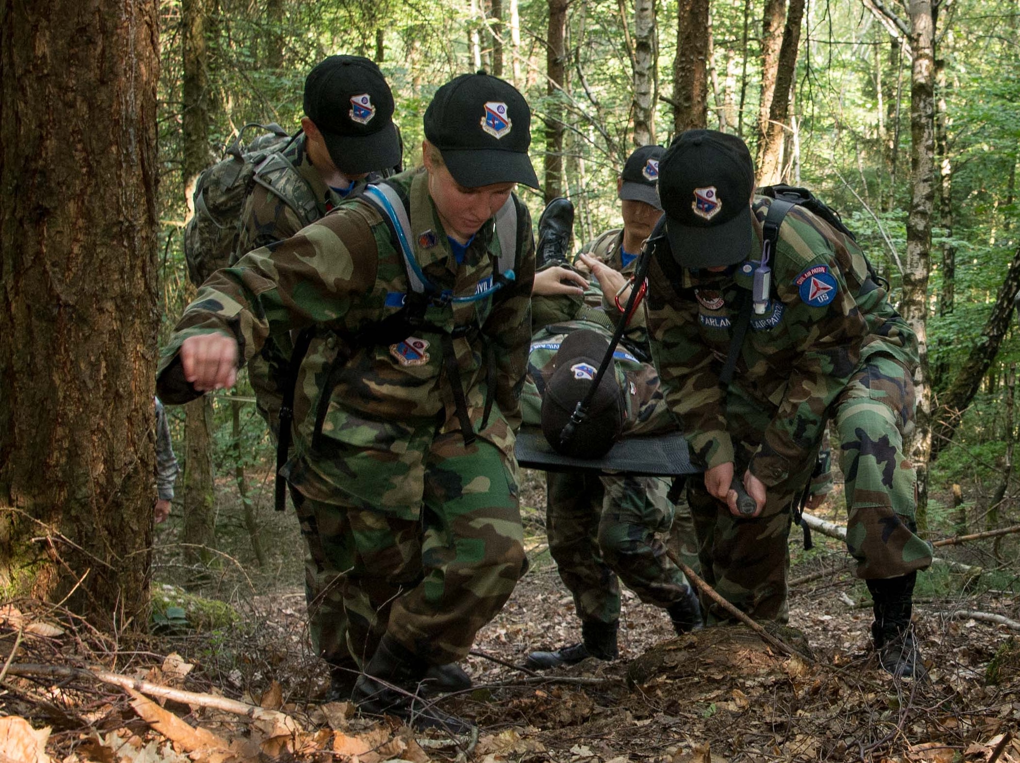 Cadets with the Civil Air Patrol European Encampment carry a stretcher bearing a fellow cadet through a woodland obstacle course on Ramstein Air Base, Germany, June 21, 2017. The cadets spent more than a week living in deployment tents on Ramstein, carrying out physical and mental tasks in a manner somewhat similar to Air Force Basic Training. (U.S. Air Force photo by Senior Airman Elizabeth Baker)