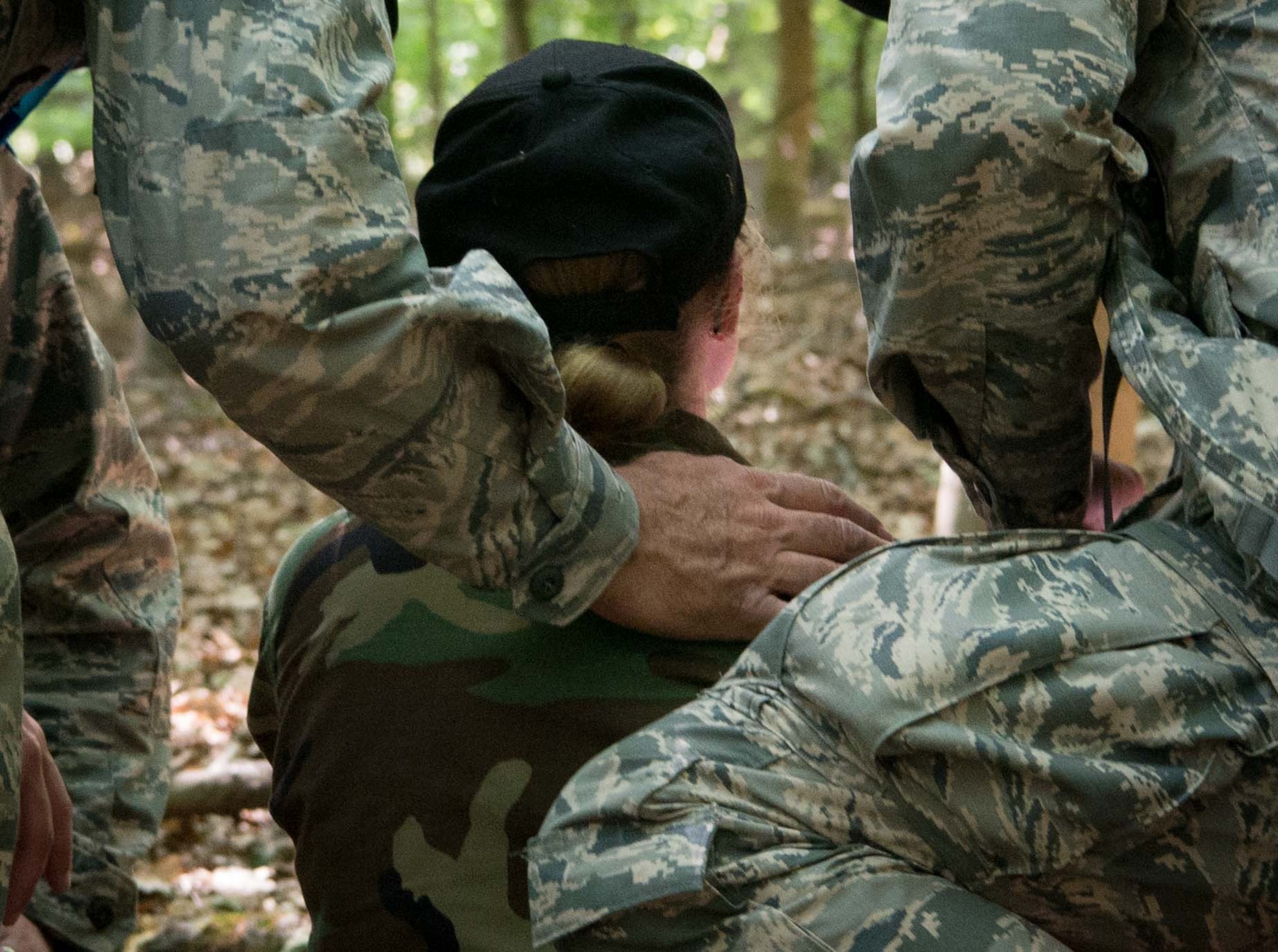 Civil Air Patrol senior member leaders comfort an overwhelmed cadet during an obstacle course challenge on Ramstein Air Base, Germany, June 21, 2017. The senior member leaders are CAP personnel who volunteer to lead encampments. They use classes, activities and experience to educate the cadets, help them build life skills and encourage them to grow into leaders. (U.S. Air Force photo by Senior Airman Elizabeth Baker)