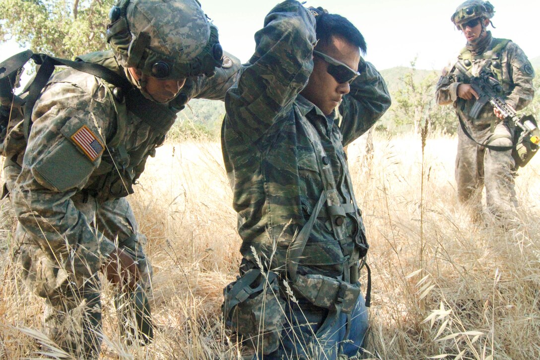 U.S. Army Reserve Spc. Mario Jaimes and Cpl. Jeremy Perez of the 341st Military Police Company, 200th Military Police Command search a captured OPFOR role player after a simulated firefight at Fort Hunter Liggett, Calif., June 19, 2017. More than 3000 U.S. Army Reserve soldiers are participating in the 84th Training Command's Warrior Exercise (WAREX) 19-17-03 at Fort Hunter Liggett, Calif.; the WAREX is a large-scale collective training platform to generate capable, lethal and combat ready forces. U.S. Army photo by Capt. Patrick Cook.