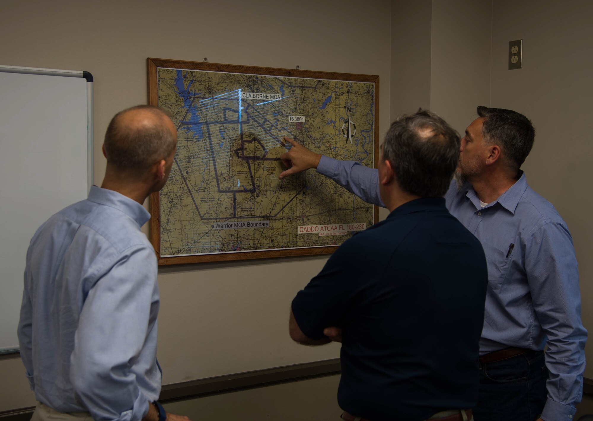 William Avants (right), 307th Operation Support Squadron range operations officer, briefs William Spacy II (left) and Roberto Guerrero (center), both from Air Force Office of the Assistant Secretary of the Air Force for Installations, Environment and Energy, about the boundaries of Claiborne Range near Alexandria, La., June 21, 2017. Col. Claiborne Range provides aircrews the opportunity to receive real time Electronic Countermeasure Training and also acts as a conventional bombing, exercise and target range for all branches of the military. (U.S. Air Force photo by Staff Sgt. Jason McCasland/Released)