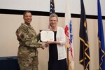 DLA Distribution deputy commander Ms. Twila Gonzales, SES, presents Master Sgt. Cynthia Stewart with the Defense Meritorious Service Award.
