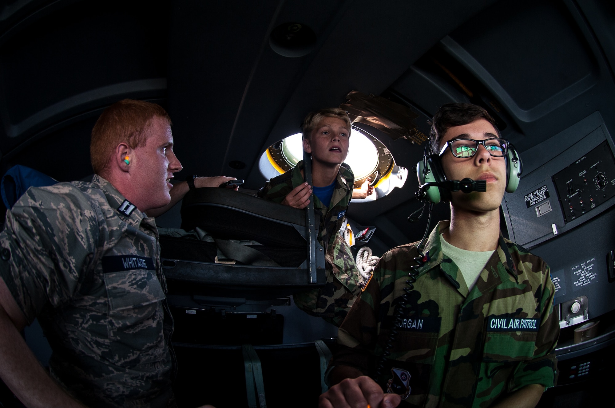 Civil Air Patrol Capt. Brad Whitacre, Wiesbaden Cadet Flight encampment deputy commander, educates Cadet Master Sgt. John Odom, Ramstein Cadet Squadron, and Cadet Airman Karim Morgan, Wiesbaden Cadet Flight, about piloting during a flight over Rheinland-Pfalz, Germany, June 20, 2017. The cadets watched pilots from the 37th Airlift Squadron operate the C-130J Super Hercules to get an idea of what it’s like to be a pilot. (U.S. Air Force photo by Senior Airman Devin Boyer)
