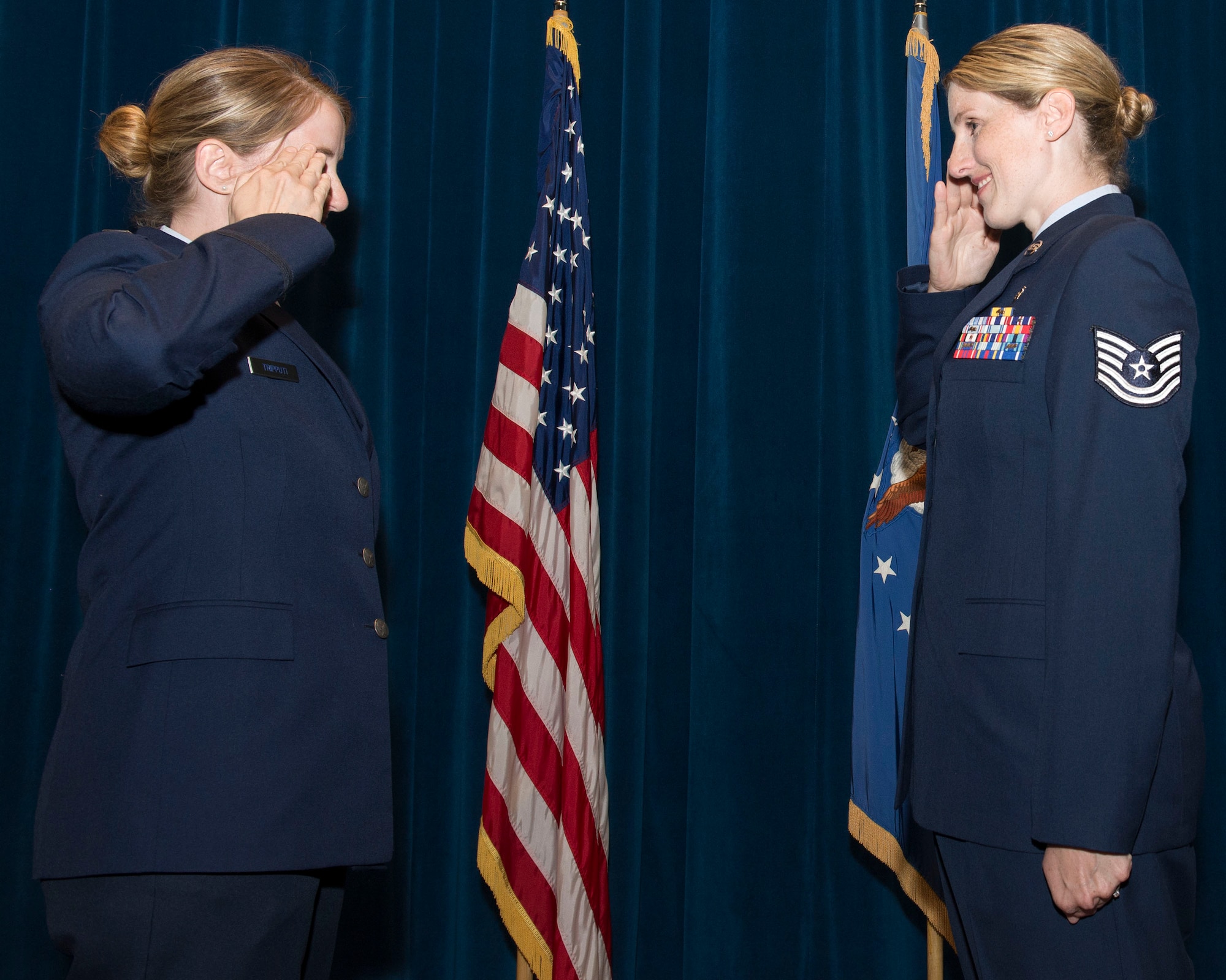 U.S. Air Force Capt. Nicole Tripputi, a contract negotiator with the 645th Aeronautical Systems Group, Big Safari, gives the oath of enlistment to her sister, Tech. Sgt. Jennifer Stem, 88th Aerospace medicine squadron ophthalmic technician, during a re-enlistment ceremony June 19 inside the auditorium of the Wright-Patterson Medical Center at Wright-Patterson Air Force Base. The two have been stationed together at WPAFB for the first time since August 2016.(U.S. Air Force photos/Michelle Gigante)