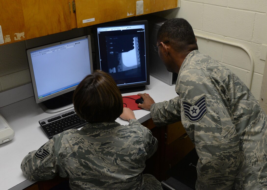 U.S. Air Force Tech. Sgt. Joanna Peacock, left, 7th Equipment Maintenance Squadron nondestructive inspection shift lead, and Tech. Sgt. Nicholas Guillory, 489th Maintenance Squadron air reserve technician, inspect an aircraft part using the NDI lab’s new computed radiography scanner at Dyess Air Force Base, Texas, June 15, 2017. With the new scanner, the NDI lab will save the base more than $6,000 on supplies that were needed for the prior method with the film radiography scanner. (U.S. Air Force photo by Airman 1st Class Rebecca Van Syoc)