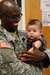 1st Lt. Douglas Ndunga, a U.S. Army Reserve staff nurse assigned to the 7226 Medical Support Unit, Fort Jackson, S.C., holds five-month-old Isaac Russell Deluna, while his mother Jannette, a Resident of El Cenizo, Texas, goes through initial patient screening during the Joint Texas A&M Colonias Innovative Readiness Training designed to train Soldiers and provide free medical, dental and optometric care to low income residents in the border regions of Web County, Texas 19-29 June 2017. (U.S. Army Reserve photo by Cpt. Joe Bush 215th Mobile Public Affairs Detachment.)