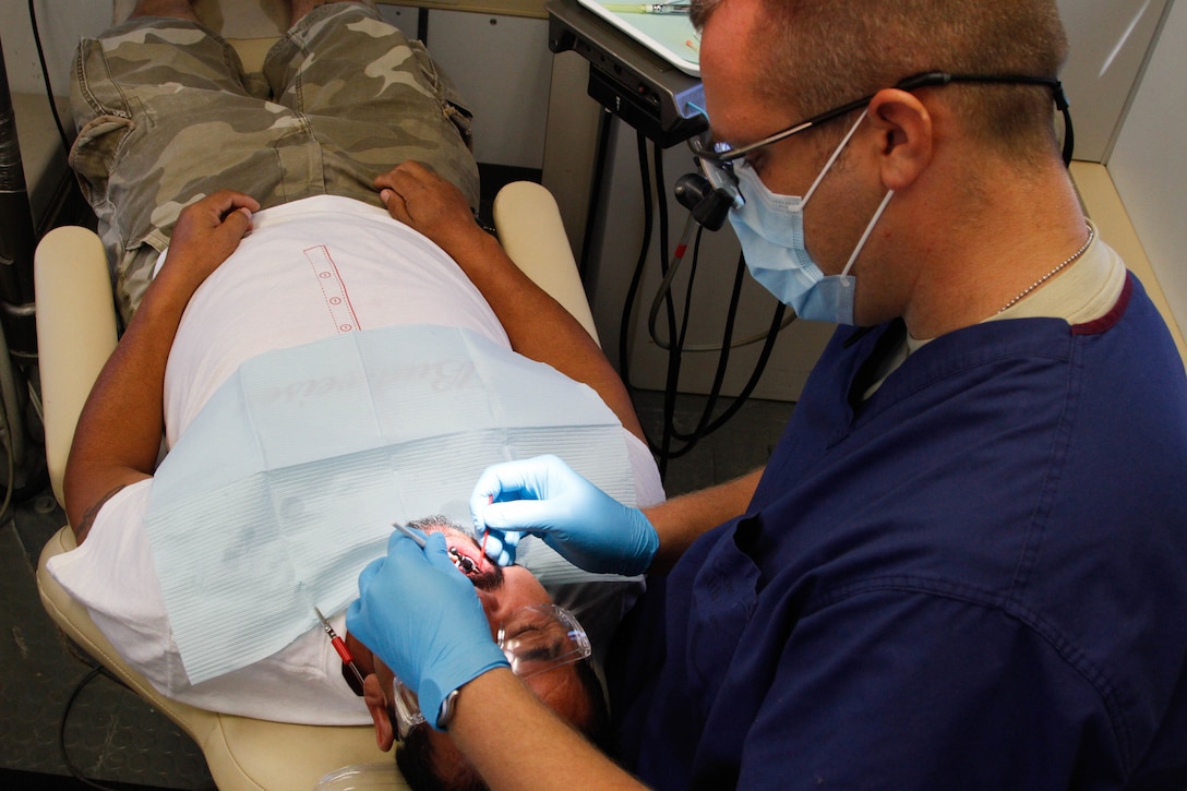 Capt. Mark Burns, a U.S. Army Reserve general dentist assigned to the 7226 Medical Support Unit, Fort Jackson, S.C., preforms a dental filling procedure on Marco Gomez, a local resident of El Cenizo, Texas during the Joint Texas A&M Colonias Innovative Readiness Training designed to train Soldiers and provide free medical, dental and optometric care to low income residents in the border regions of Web County, Texas 19-29 June 2017. (U.S. Army Reserve photo by Cpt. Joe Bush 215th Mobile Public Affairs Detachment.)