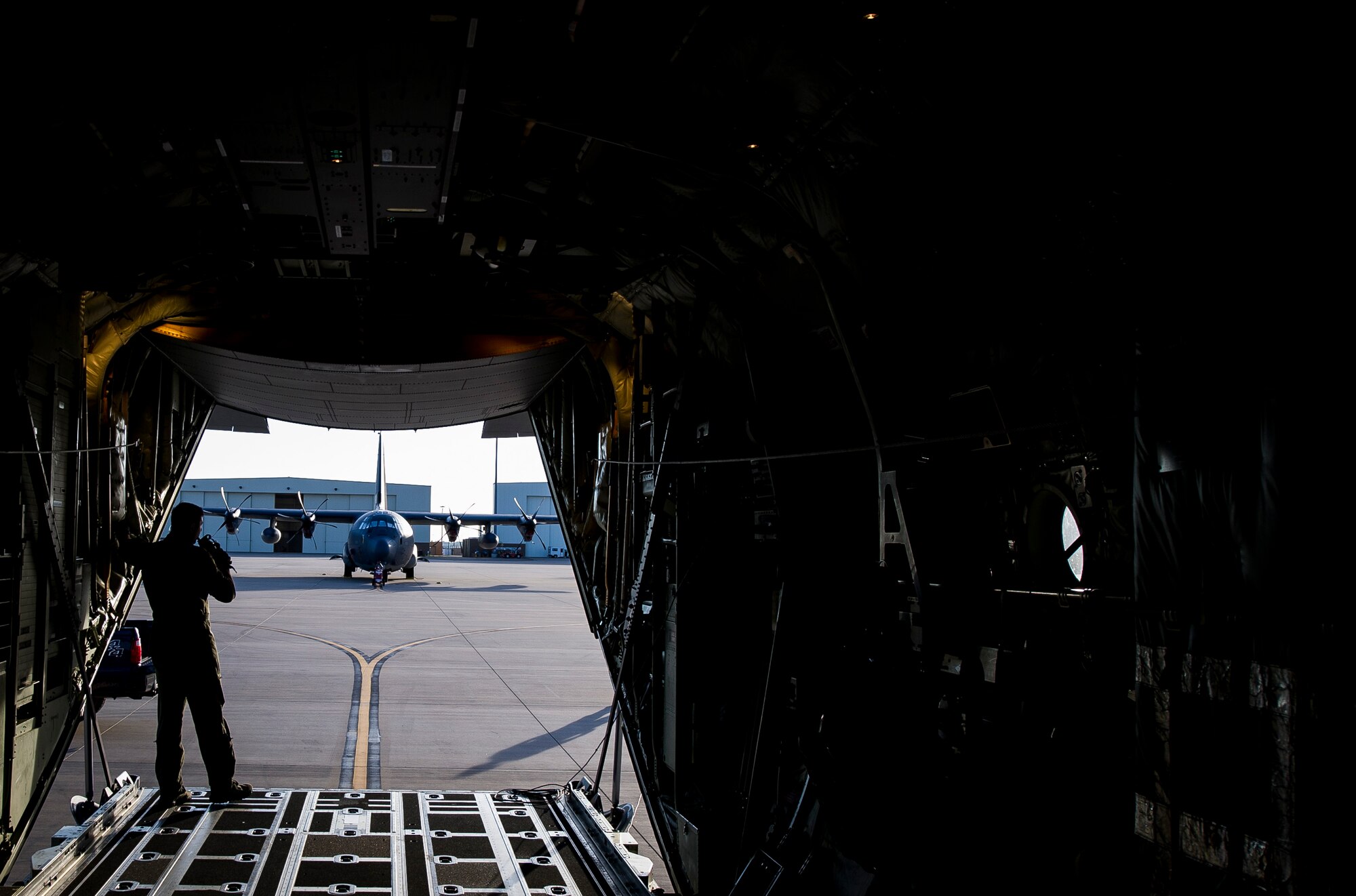 An Airman from the 9th Special Operations Squadron peers out from the back of an aircraft used for a ‘fini flight’ early in the morning at Cannon Air Force Base, New Mexico, Jun. 9, 2017. Dating back to World War II, the U.S. military has celebrated pilots’ and other experienced officers’ final flights either at their current unit or their career. Pilots use these celebrations as another opportunity to help train accompanying Airmen on their roles aboard the aircraft to ensure mission readiness. (U.S. Air Force photo by Senior Airman Lane T. Plummer)