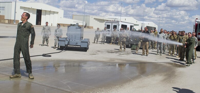 Col. Benjamin Maitre, former 27th Special Operations Wing commander, is sprayed by his coworkers after completing his final flight at Cannon Air Force Base, New Mexico, Jun. 1, 2017. Dating back to World War II, the U.S. military has celebrated pilots’ and other experienced officers’ final flights either at their current unit or their career. Pilots use these celebrations as another opportunity to help train accompanying Airmen on their roles aboard the aircraft to ensure mission readiness. (U.S. Air Force photo by Senior Airman Lane T. Plummer)
