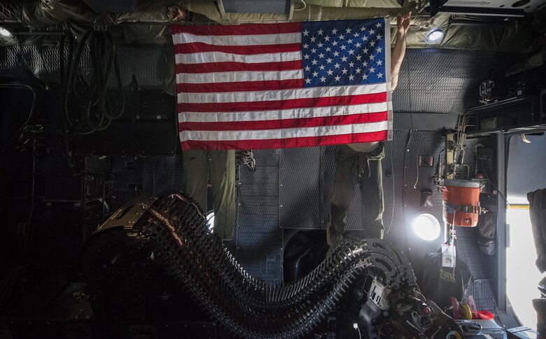 Airmen from the 16th Special Operations Squadron hang up the U.S. flag as they prepare for takeoff during a ‘fini flight’ at Cannon Air Force Base, New Mexico, Jun. 9, 2017. Dating back to World War II, the U.S. military has celebrated pilots’ and other experienced officers’ final flights either at their current unit or their career. Pilots use these celebrations as another opportunity to help train accompanying Airmen on their roles aboard the aircraft to ensure mission readiness. (U.S. Air Force photo by Senior Airman Lane T. Plummer)