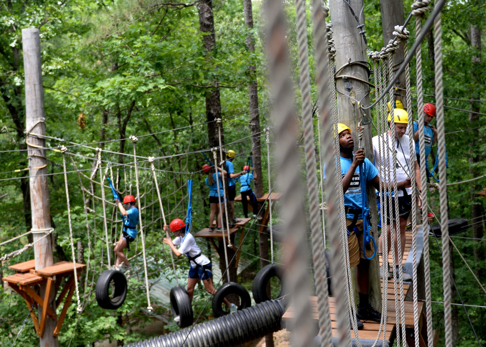 Gold Star children and U.S. Air Force volunteers make their way through an obstacle course June 15, 2017, at the Hearts of Our Heroes Camp in Little Rock, Ark. The obstacle course consisted of tire swings, rope walks and a zip line. (U.S. Air Force photo by Airman 1st Class Codie Collins)
