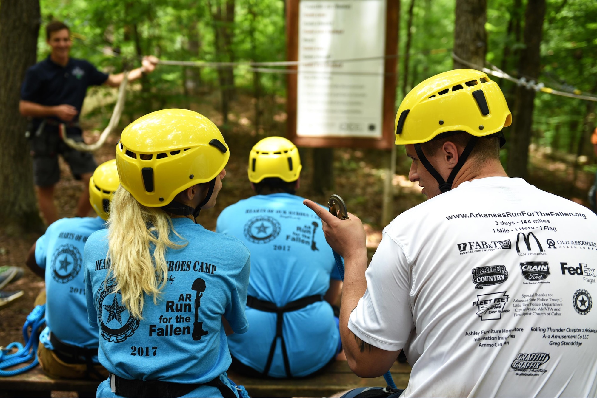 Ariana Ramirez, a Gold Star daughter, and Staff Sgt. Christian Chessor, 19th Security Forces Squadron Pass and Registration NCO in charge, recite zip line safety rules to each other June 15, 2017, at the Hearts of Our Heroes Camp in Little Rock, Ark. The Gold Star program’s mission is to serve families of fallen service members by providing resources that promote resiliency and keeping the families connected to the military as long as they desire. (U.S. Air Force photo by Airman 1st Class Kevin Sommer Giron)