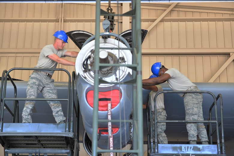 Airmen Douglas Price, Aaron Mack and Carlos Edwards, 361st Training Squadron students learn how to remove and secure the power package to the T-56 engine at Sheppard Air Force Base, Texas. This is a quick engine change stand assembly. (U.S. Air Force photo by Liz H. Colunga/Released)