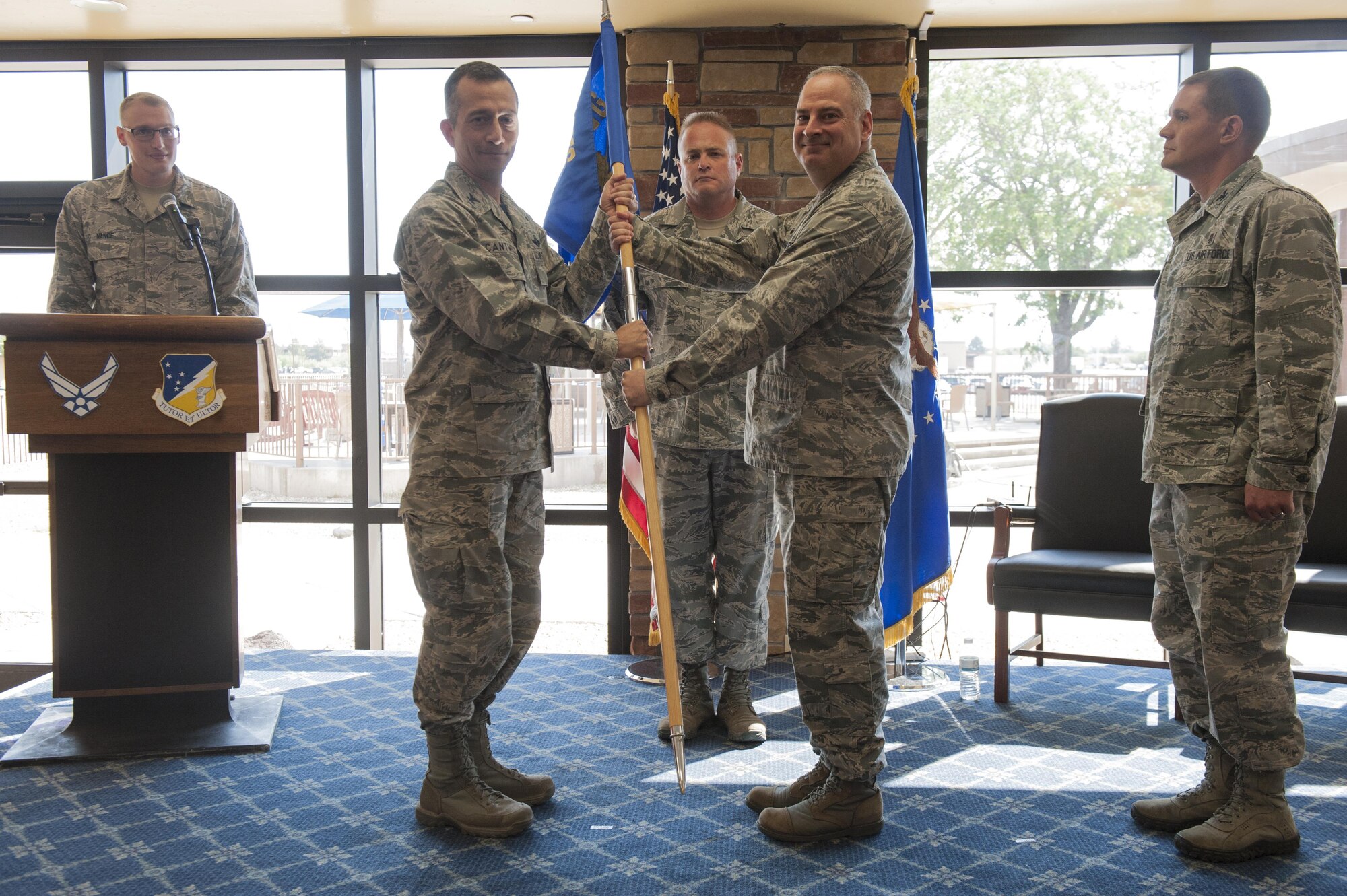 Col. Houston R. Cantwell, 49th Wing commander, takes the 49th Medical Group guidon from Col. Paul A. Willingham, 49th MDG outgoing commander, during a change of command ceremony at Club Holloman, June 23, 2017. During the ceremony, Willingham relinquished command of the 49th MDG to Col. Paul R. Brezinski. (U.S. Air Force photo by Airman 1st Class Ilyana A. Escalona)