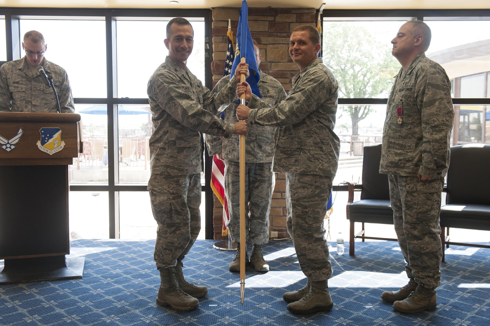 Col. Houston R. Cantwell, 49th Wing commander, gives the 49th Medical Group guidon to Col. Paul R. Brezinski during a change of command ceremony at Club Holloman, June 23, 2017. During the ceremony, Col. Paul R. Brezinski took command of the 49th MDG from Col. Paul A. Willingham, 49th MDG outgoing commander. (U.S. Air Force photo by Airman 1st Class Ilyana A. Escalona)