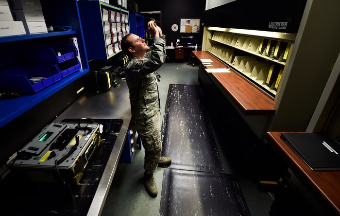 Staff Sgt. Brian Spears, 437th Operation Support Squadron aircrew flight equipment NCO in charge of night vision goggle combat survival evader locaters, inspects the integrity of a piece of aircrew equipment at Joint Base Charleston, S.C., June 20. Airmen assigned to the 437th OSS AFE flight ensure that aircrew equipment including helmets, oxygen masks, life rafts, and parachutes are safe and ready to operate.