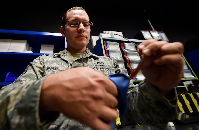 Staff Sgt. Brian Spears, 437th Operation Support Squadron aircrew flight equipment NCO in charge of night vision goggle combat survival evader locaters, inspects the integrity of a piece of aircrew equipment at Joint Base Charleston, S.C., June 20. Airmen assigned to the 437th OSS AFE flight ensure that aircrew equipment including helmets, oxygen masks, life rafts, and parachutes are safe and ready for aircrew members to operate. 