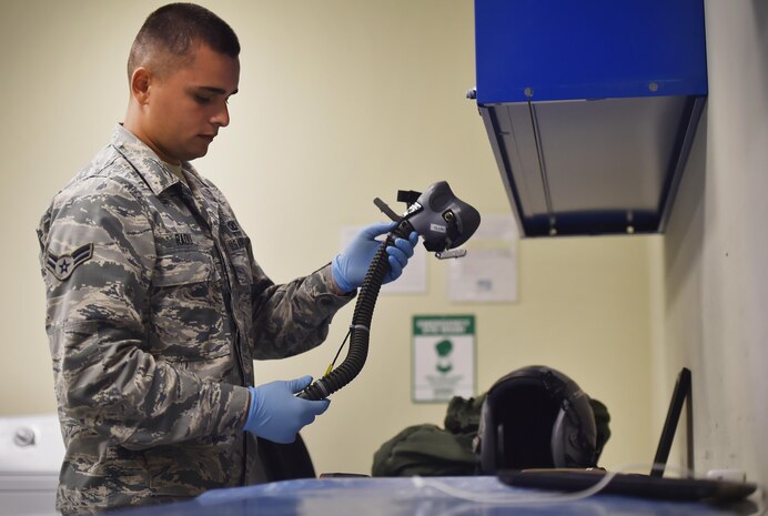 Airman 1st Class Ion Radu, 437th Operation Support Squadron aircrew flight equipment, inspects a helmet and oxygen mask at Joint Base Charleston, S.C., June 20. Airmen assigned to the 437th OSS AFE flight ensure that aircrew equipment including helmets, oxygen masks, life rafts, and parachutes are safe and ready for aircrew members to operate.