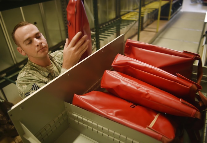 Staff Sgt. Christopher Mills 437th Operations Support Squadron aircrew flight equipment craftsman and flightline work center NCO in charge, places passenger demo kits in a storage unit at Joint Base Charleston, S.C., June 22. Passenger demo kits provide aircrew members with a life preserver and emergency passenger oxygen system. Airmen assigned to the 437th OSS AFE flight ensure that aircrew equipment including helmets, oxygen masks, life rafts, and parachutes are safe and ready for aircrew members to operate. 