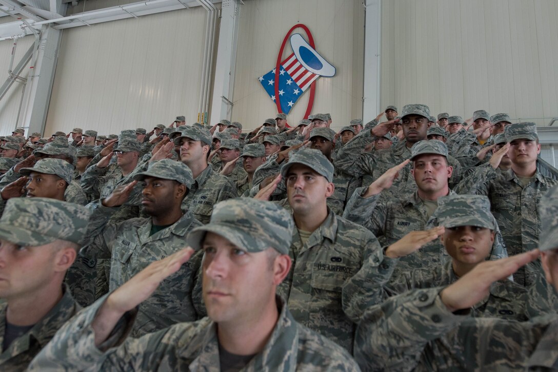Airmen of Joint Base Langley-Eustis, Va. render a salute during the national anthem at the 1st Fighter Wing change of command, June 23, 2017. At the change of command U.S. Air Force Col. Peter Fesler relinquished command to U.S. Air Force Col. Jason Hinds. (U.S. Air Force photo/Staff Sgt. Carlin Leslie)