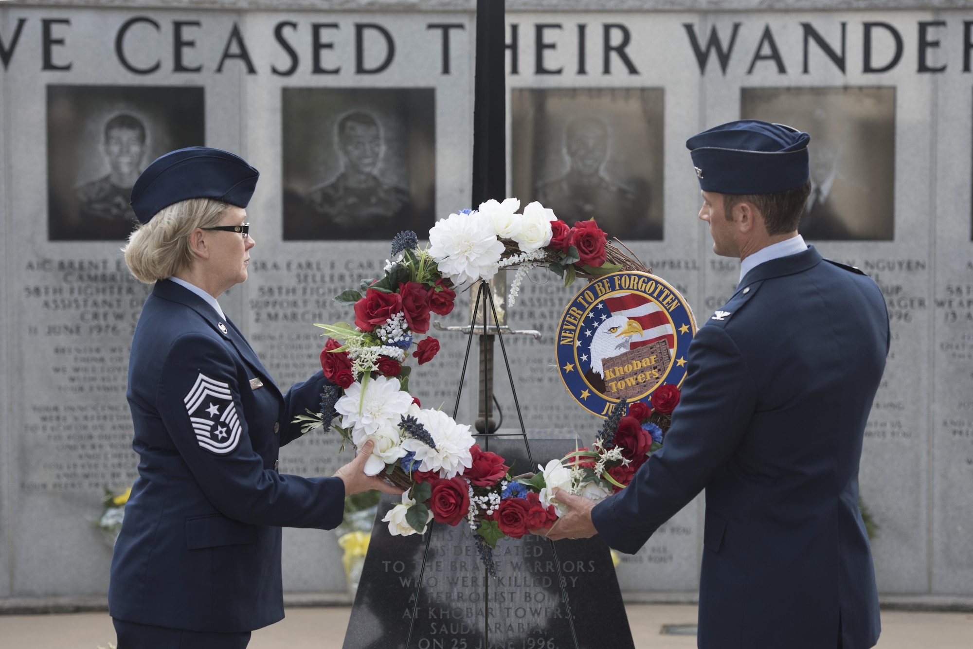 U.S. Air Force Col. Paul Moga, 33rd Fighter Wing commander, right, and Chief Master Sgt. Shelley Cohen, 307th Bomb Wing command chief, place a wreath in front of the burning sword during the Khobar Towers 21st Anniversary Wreath Laying Ceremony June 23, 2017, at Eglin Air Force Base, Florida. On June 25, 1996, a bomb was detonated near the Khobar Towers housing complex in Dhahran, Saudi Arabia. Nineteen Airmen were killed and more than 400 U.S. and international military and civilians were injured in the blast.  Of the 19 killed, 12 were Nomads. Each year the 33 FW holds a ceremony in remembrance of that day. (U.S. Air Force photo by Staff Sgt. Peter Thompson)